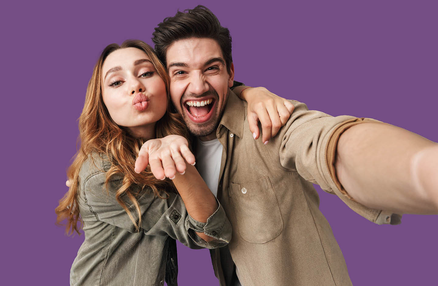 Junger Mann lächelt und junge Frau zeigt Kuss-Mund